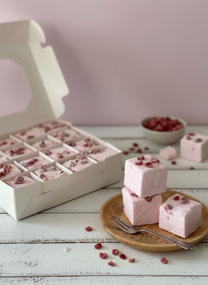 Pink marshmallows with red seeds on a wooden plate and in a box against a light pink background. sugar, water, glucose syrup, beef gelatine (E441),

natural Vanilla extract,natural coconut flavour,

desiccated coconut , icing sugar, corn starch,

citric acid (E330), salt, vegetable glycerine (3%), preservative: potassium sorbate, salt, icing sugar, corn starch, rice bran oi